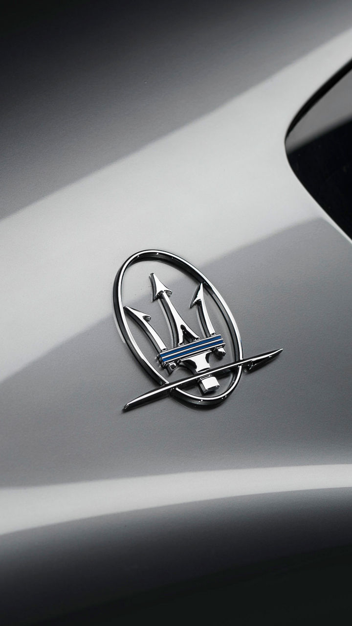 Detailaufnahme von Maseratis Dreizack Logo auf einem silbernen Maserati