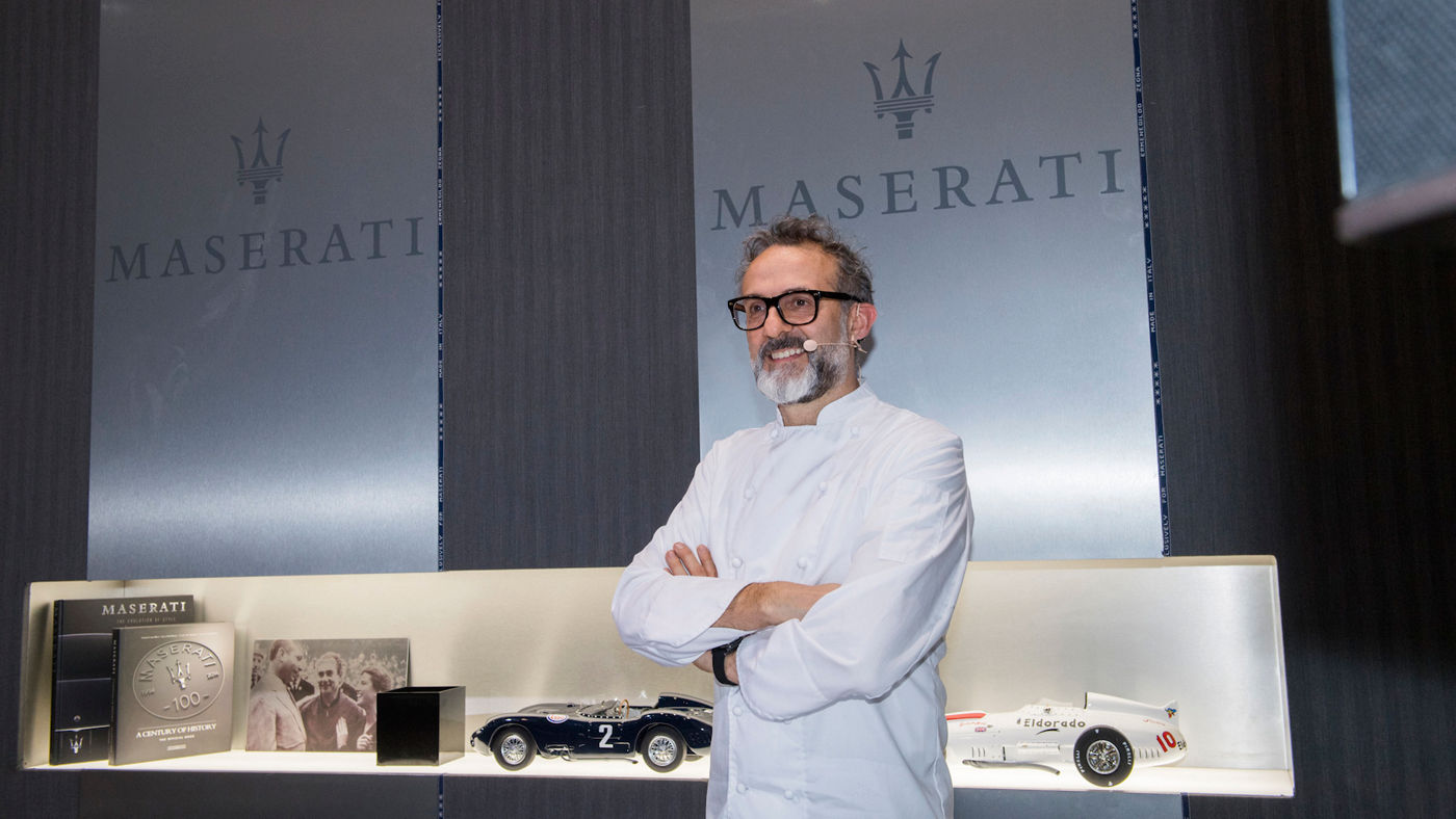 Massimo Bottura en cocina con logos Maserati