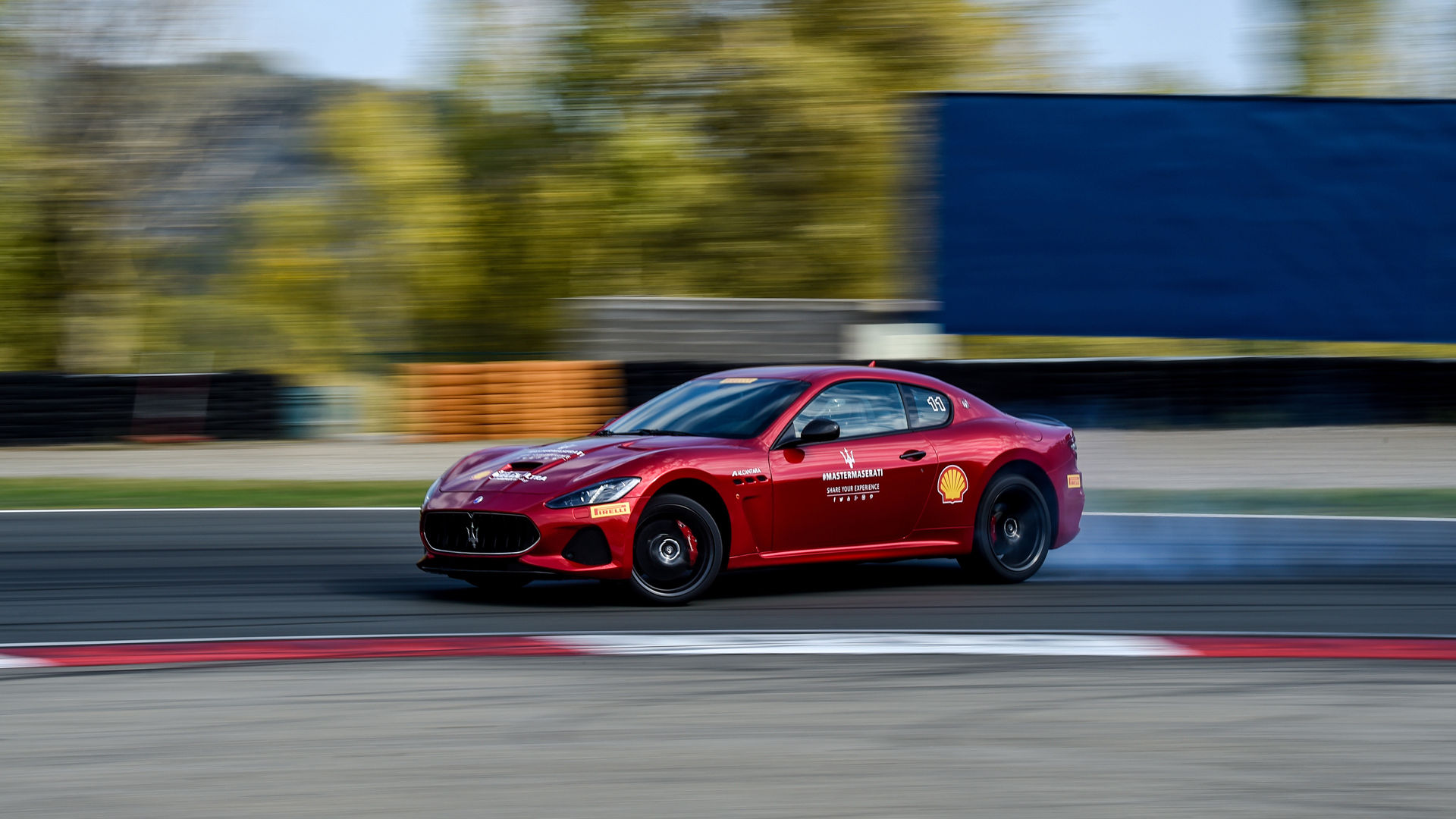 Maserati GranTurismo with partners' logos running on a circuit
