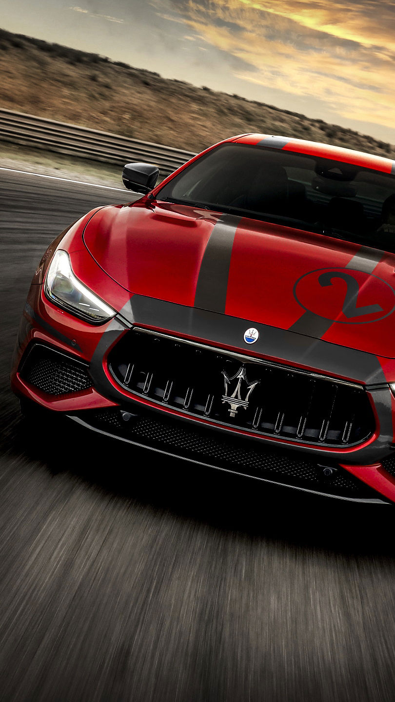 Front view of red and grey Maserati Ghibli Trofeo on racetrack