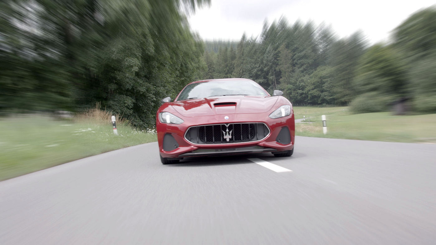 GranTurismo riding in the middle of a road 