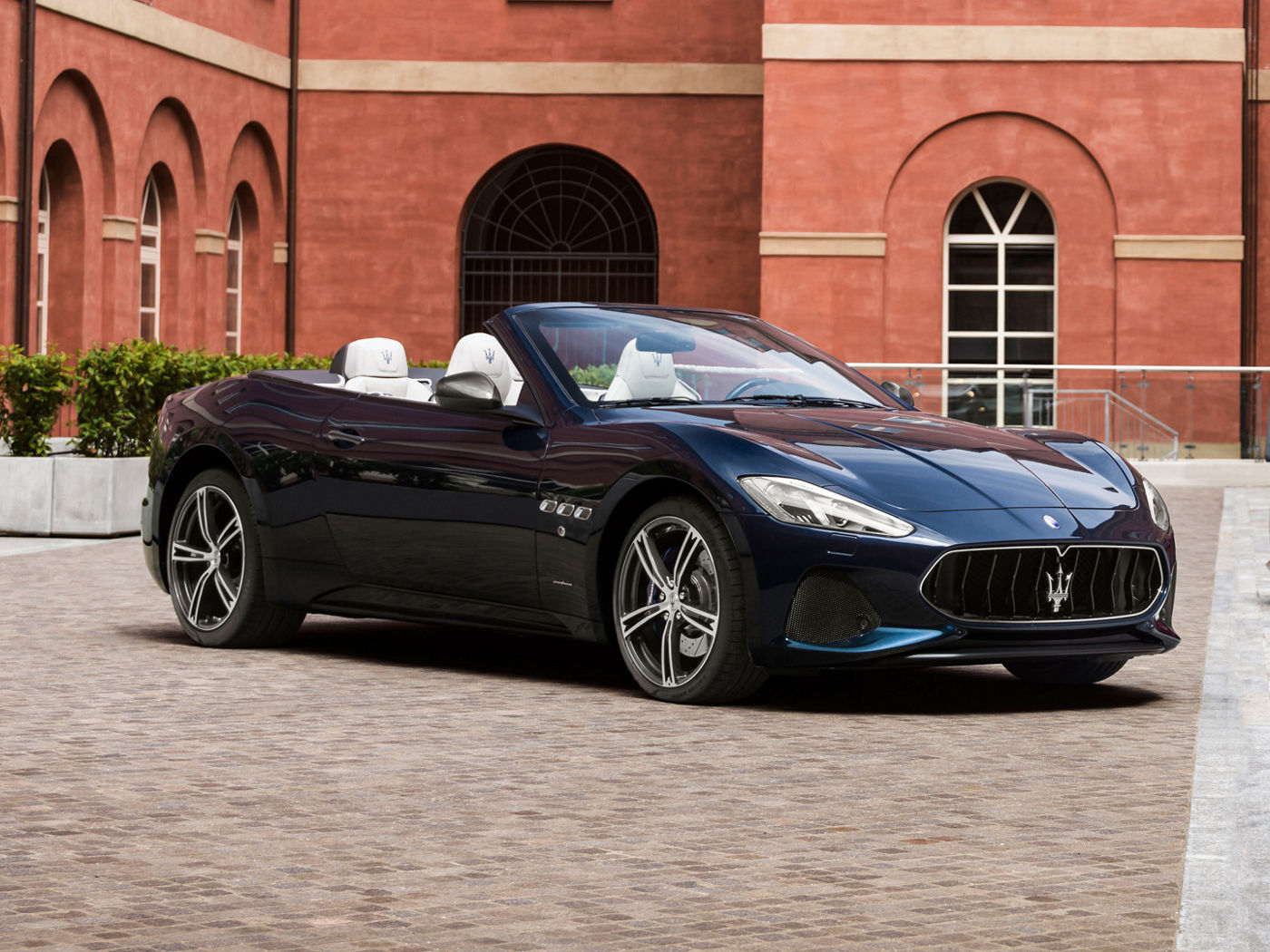 Black Maserati GranCabrio parked in front of building