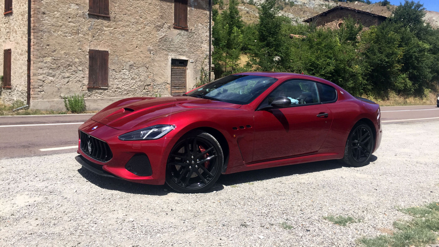 Red GranTurismo parked near an old house