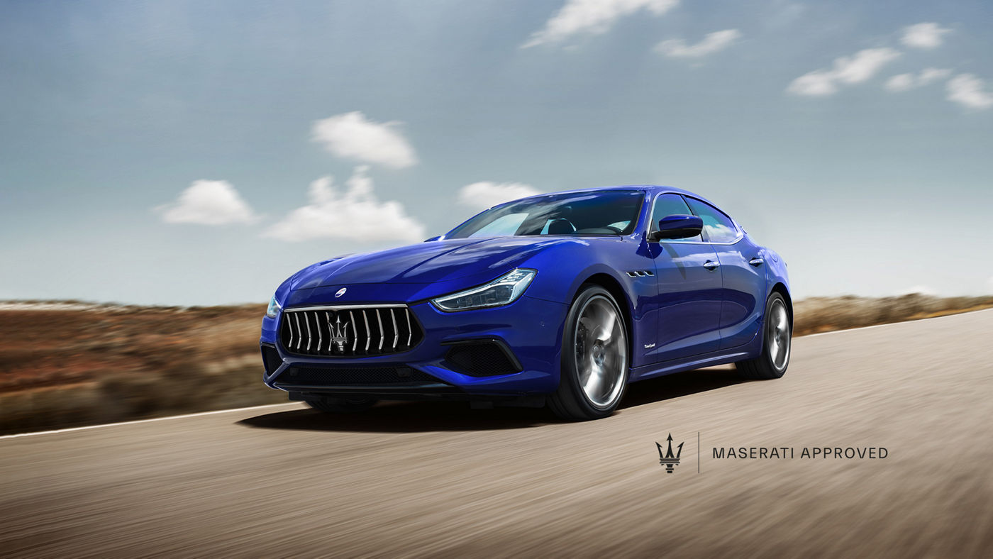 Sedán azul Maserati Ghibli por la calle