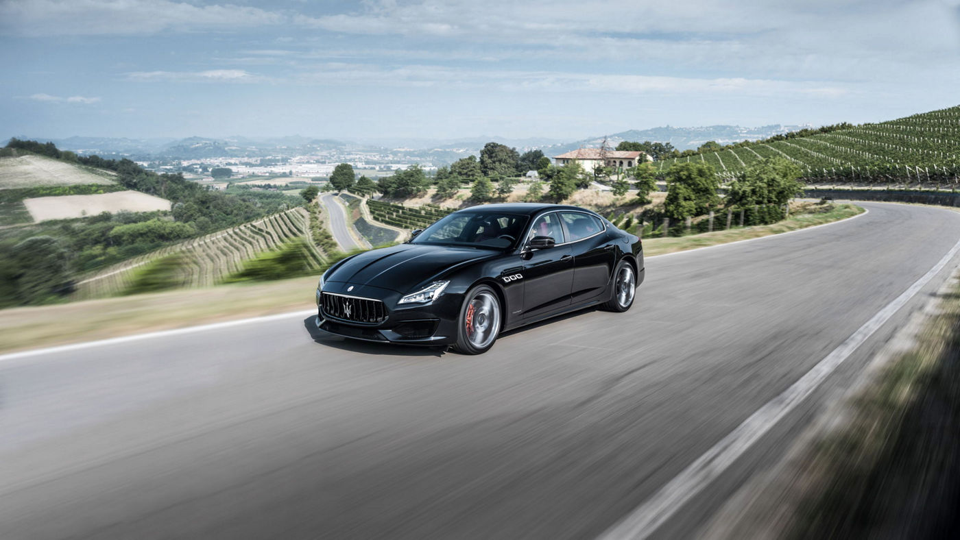 Front and side view of a black Maserati Quattroporte driving in countryside - all-wheel drive system
