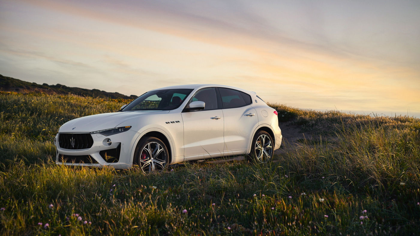View of white Maserati Levante in the middle of a field