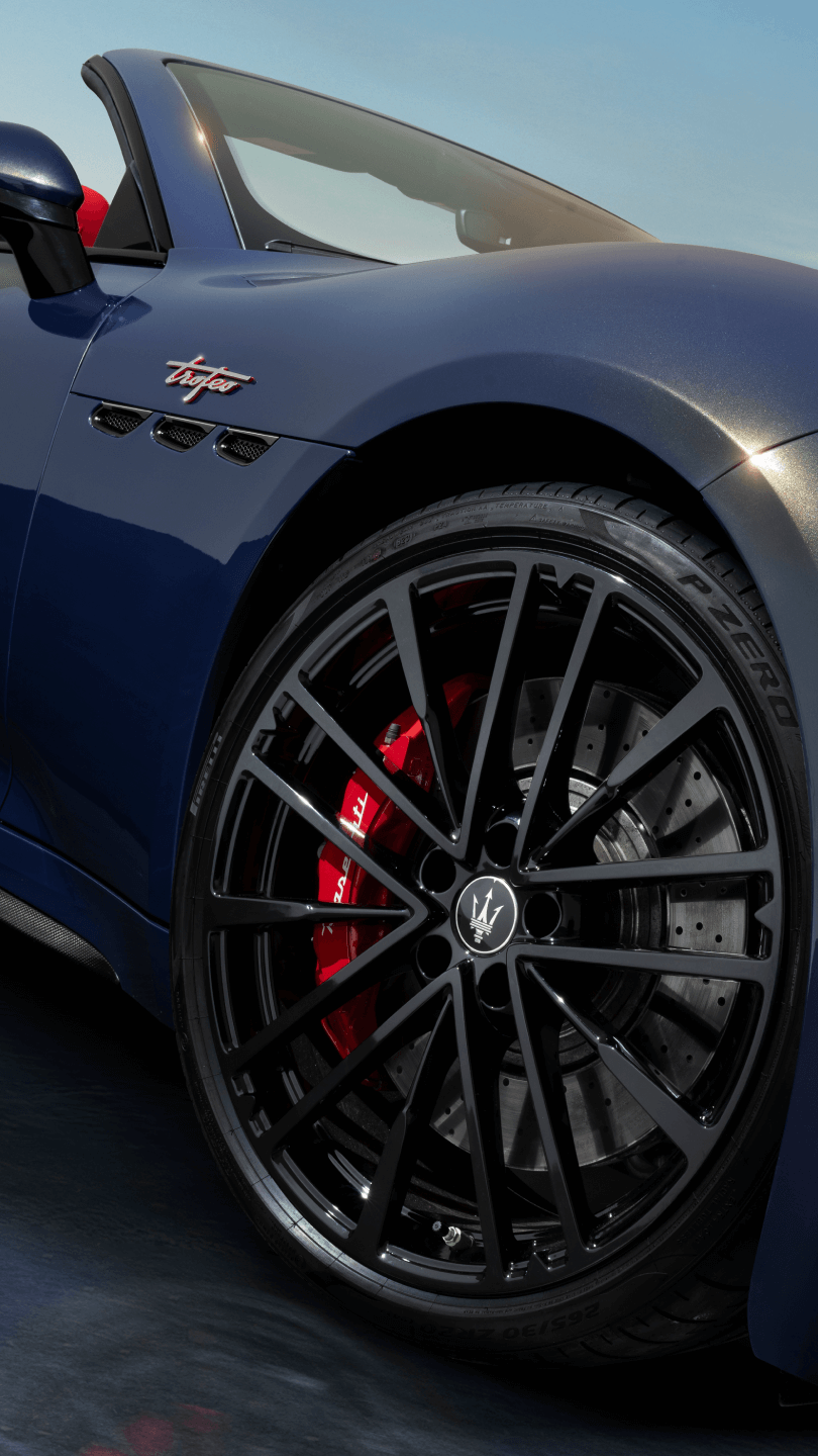 La nuova Maserati GranCabrio blu vista dal basso sul lato destro, con dettaglio della pinza freno di colore rosso.