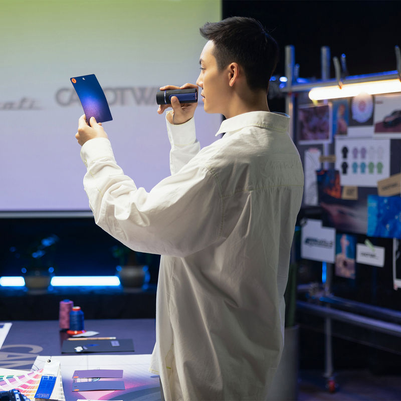 William Chan looking at sheet of color with a flashlight