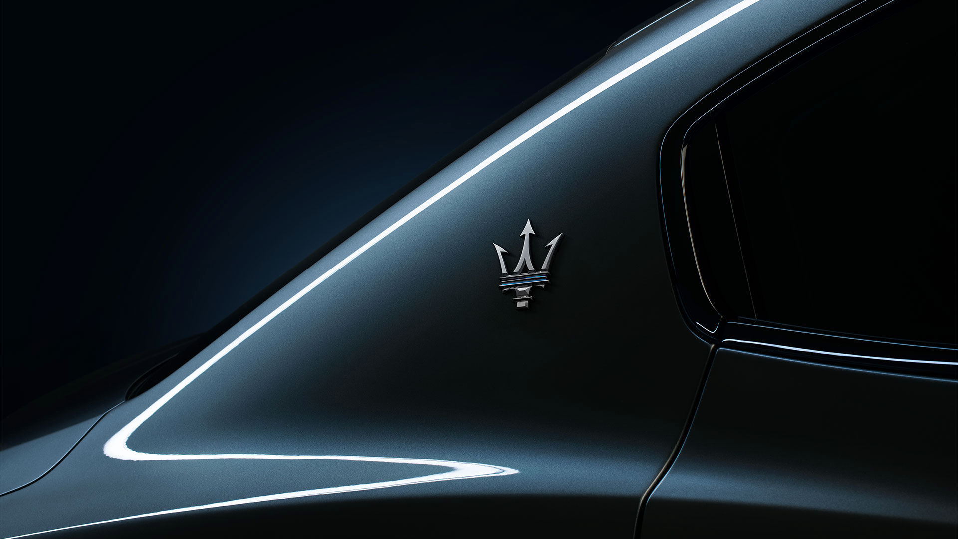 Detail of Maserati logo on gray Ghibli Hybrid