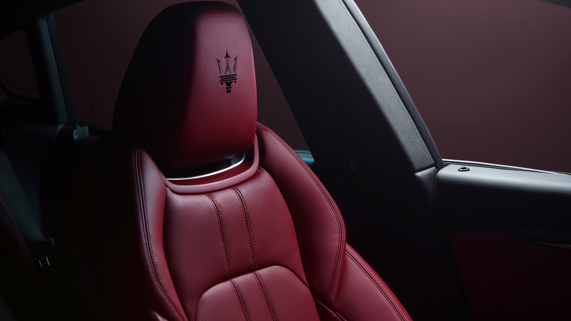 Czerwony fotelik we wnętrzu SUV-a Maserati Levante