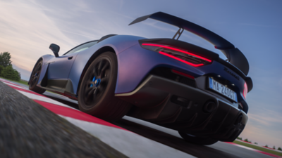 Rear perspective from below with a view of the left wheel, left rear light and wing of the Maserati GT2 Stradale passing over a curb