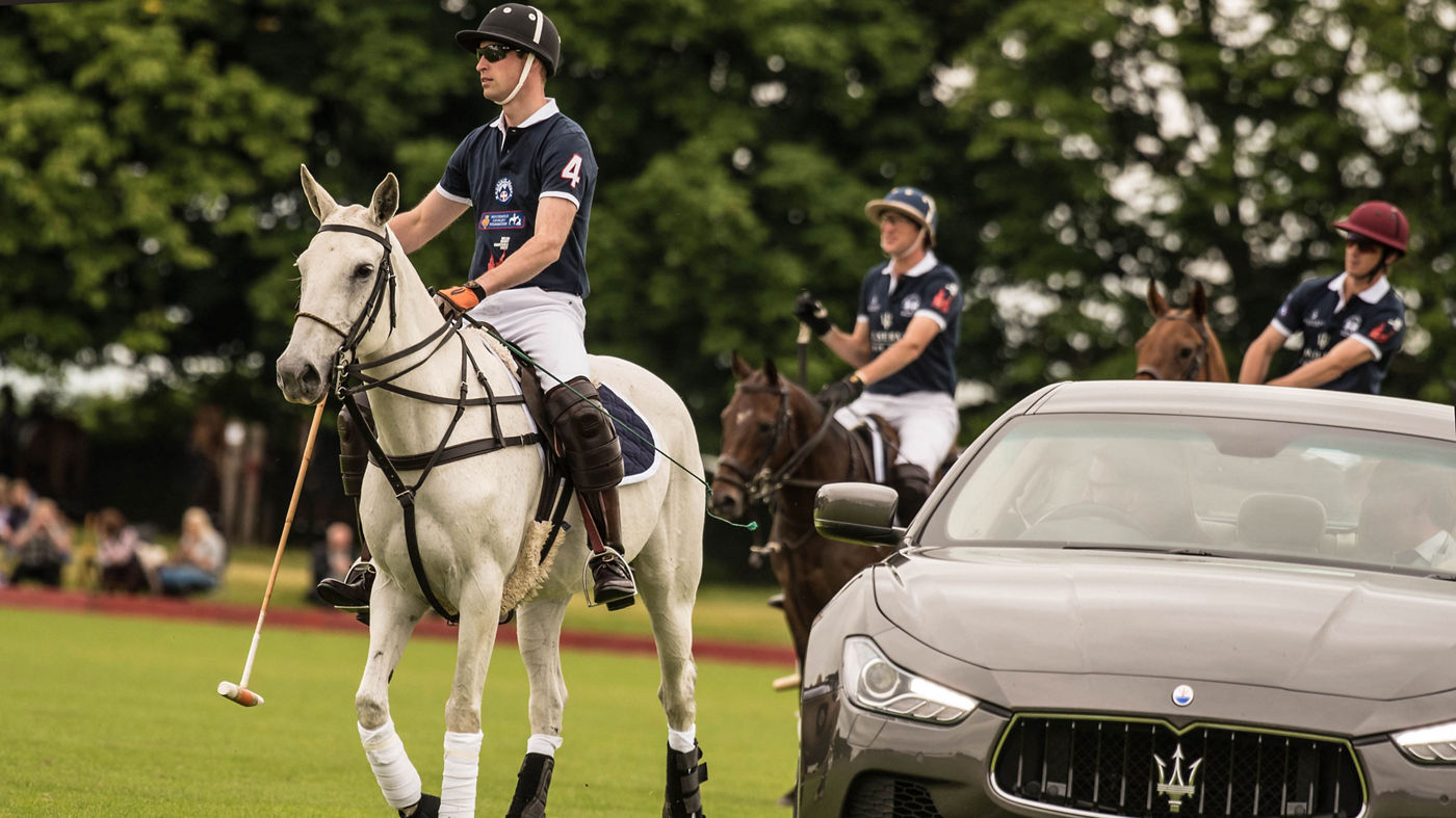 Maserati Ghibli on the polo field with player by his side