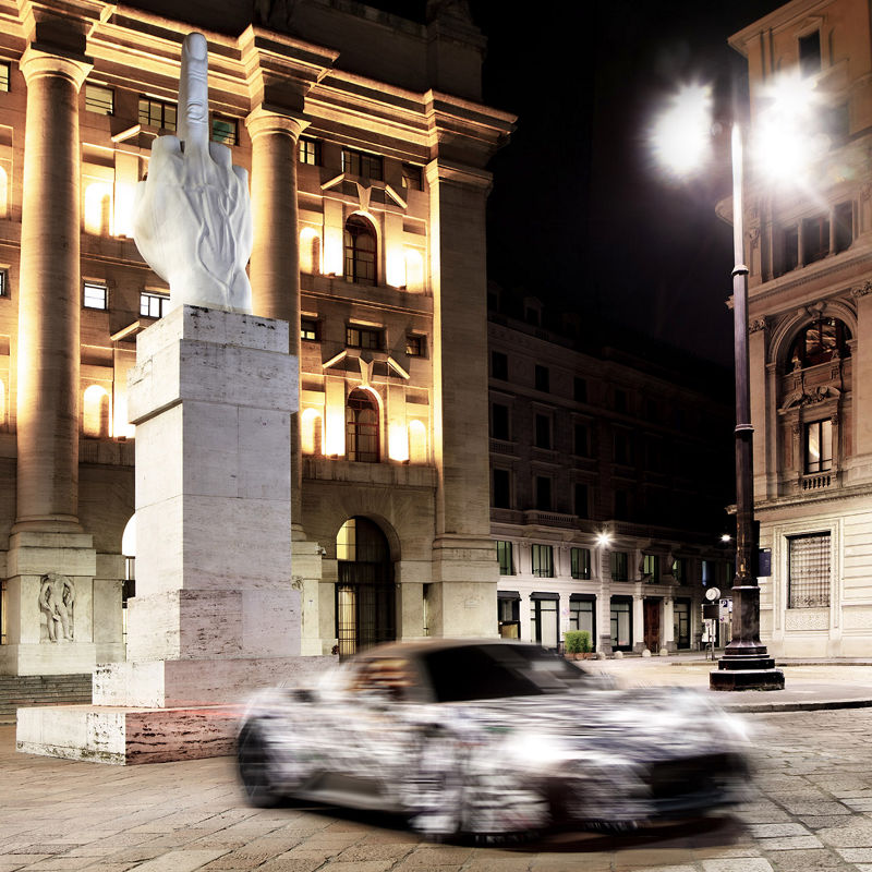 Prototipo del nuevo superdeportivo Maserati MC20 - Vista frontal del vehículo en movimiento a los pies de la escultura de Maurizio Cattelan L.O.V.E en Milán.