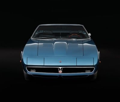 Maserati Ghibli Spyder in aquamarine blue: front view on an abstract black background