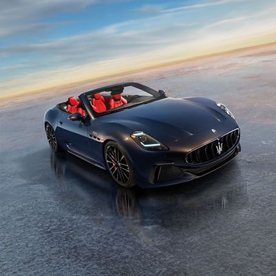 Example of the Maserati GranCabrio Trofeo cabriolet in blue with red interior, seen from the front right side in the open air