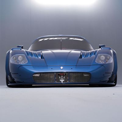 Example of a dark blue Maserati MC12 seen from the front on a gray set illuminated from above