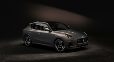 Right side view of a 'Grigio lava' colored Maserati Grecale SUV on a carbon-grey background