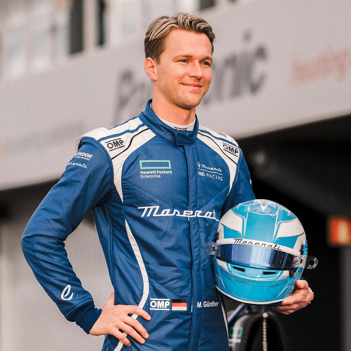 Maximilian Günther - in Maserati MSG Racing uniform - posing holding up his helmet