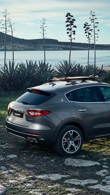 Maserati Levante, side view - on the road with a winter landscape background