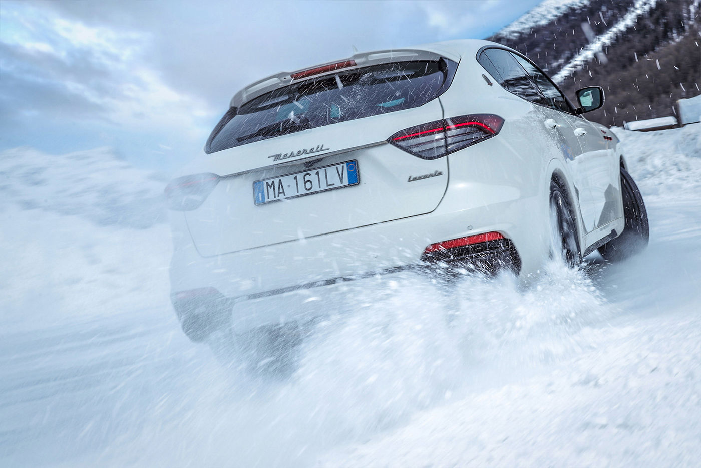 Maserati Levante fährt auf Schnee - Ansicht von hinten