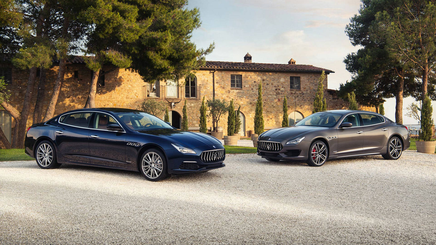Zwei Maserati Quattroporte geparkt vor einem italienischen Haus
