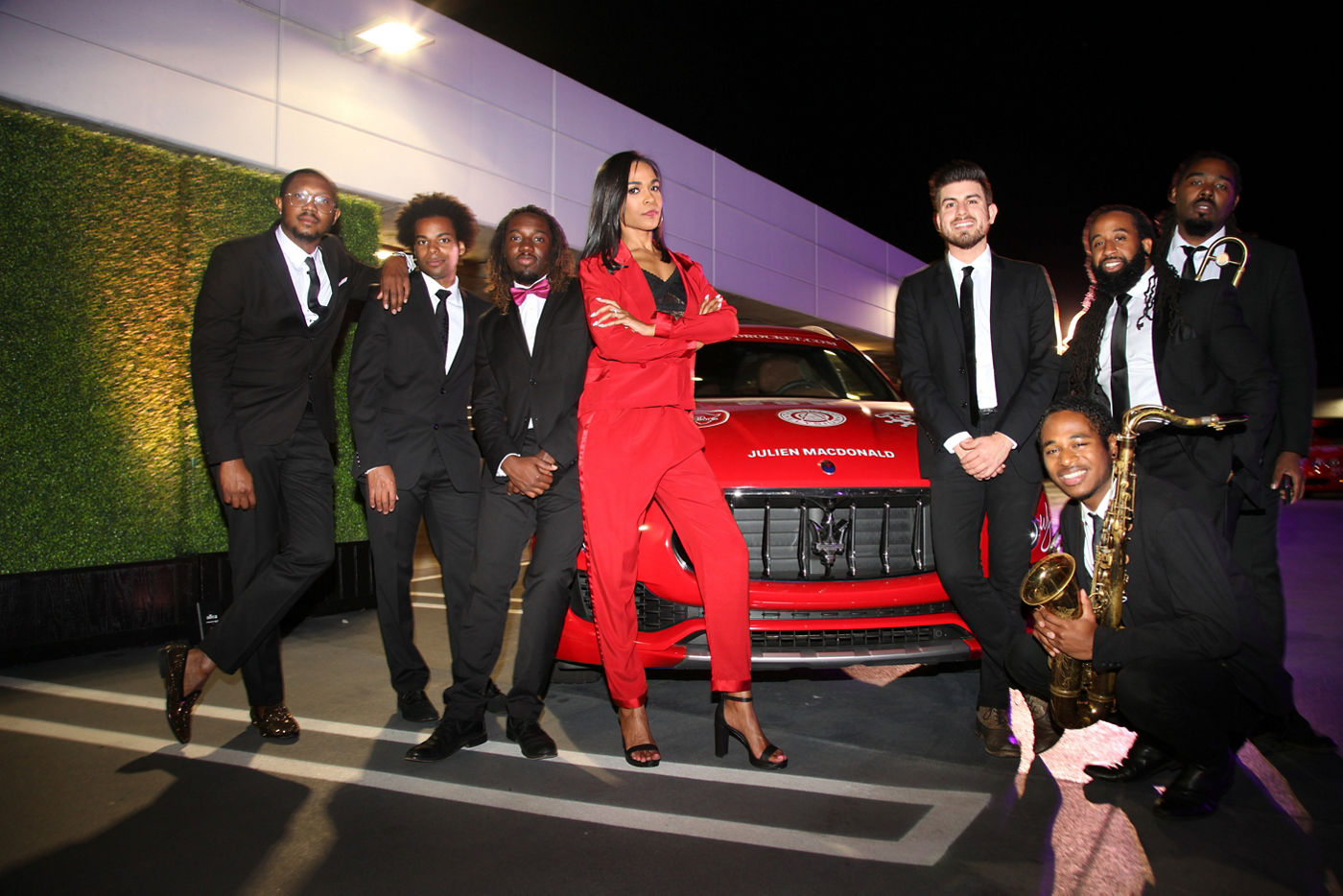Michelle Williams al lado de una banda y de un Maserati Levante