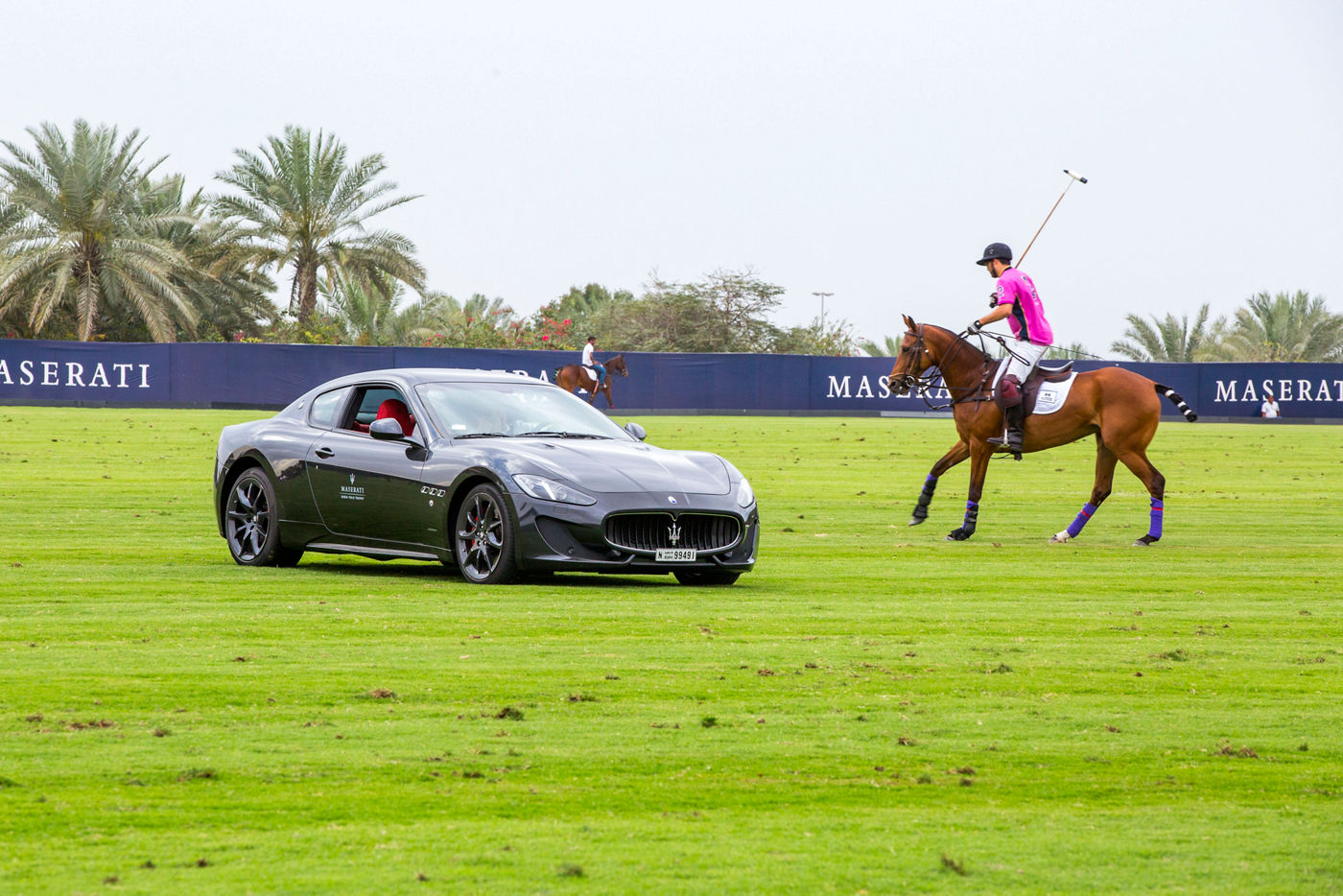 Jugador de polo cerca de un modelo Maserati 