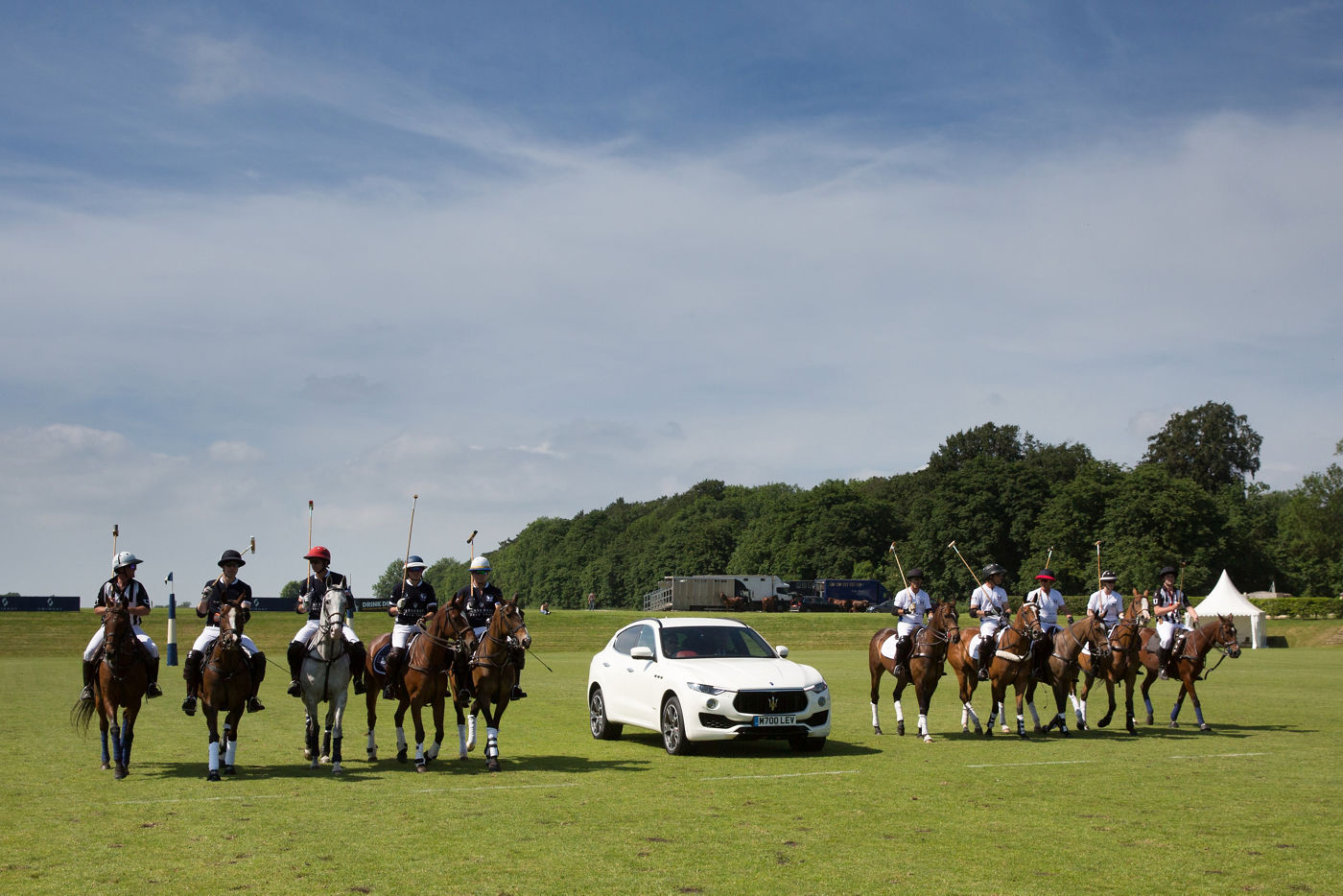 Jugadores de polo cerca del Maserati Levante en un campo