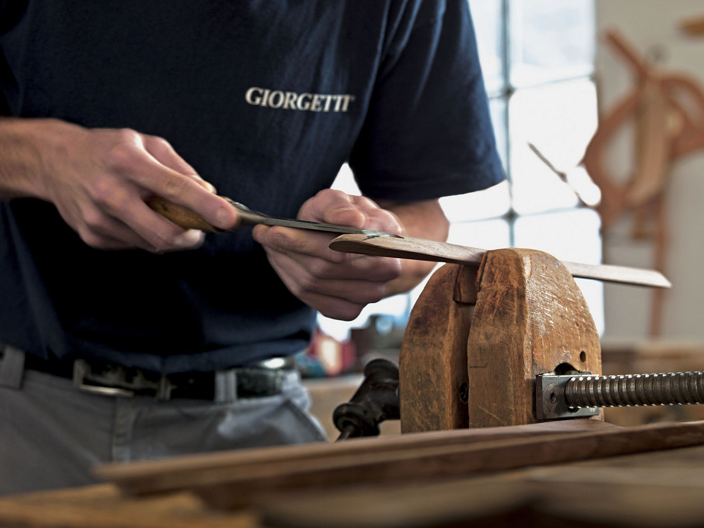 Hombre que lleva camiseta Giorgetti tallando madera