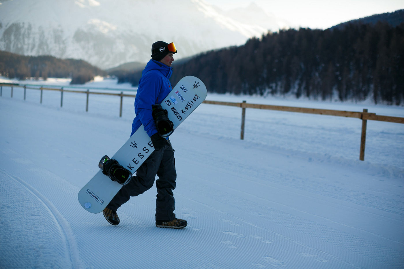 Jamie Barrow con tabla de snowboard con logo Maserati en la nieve 