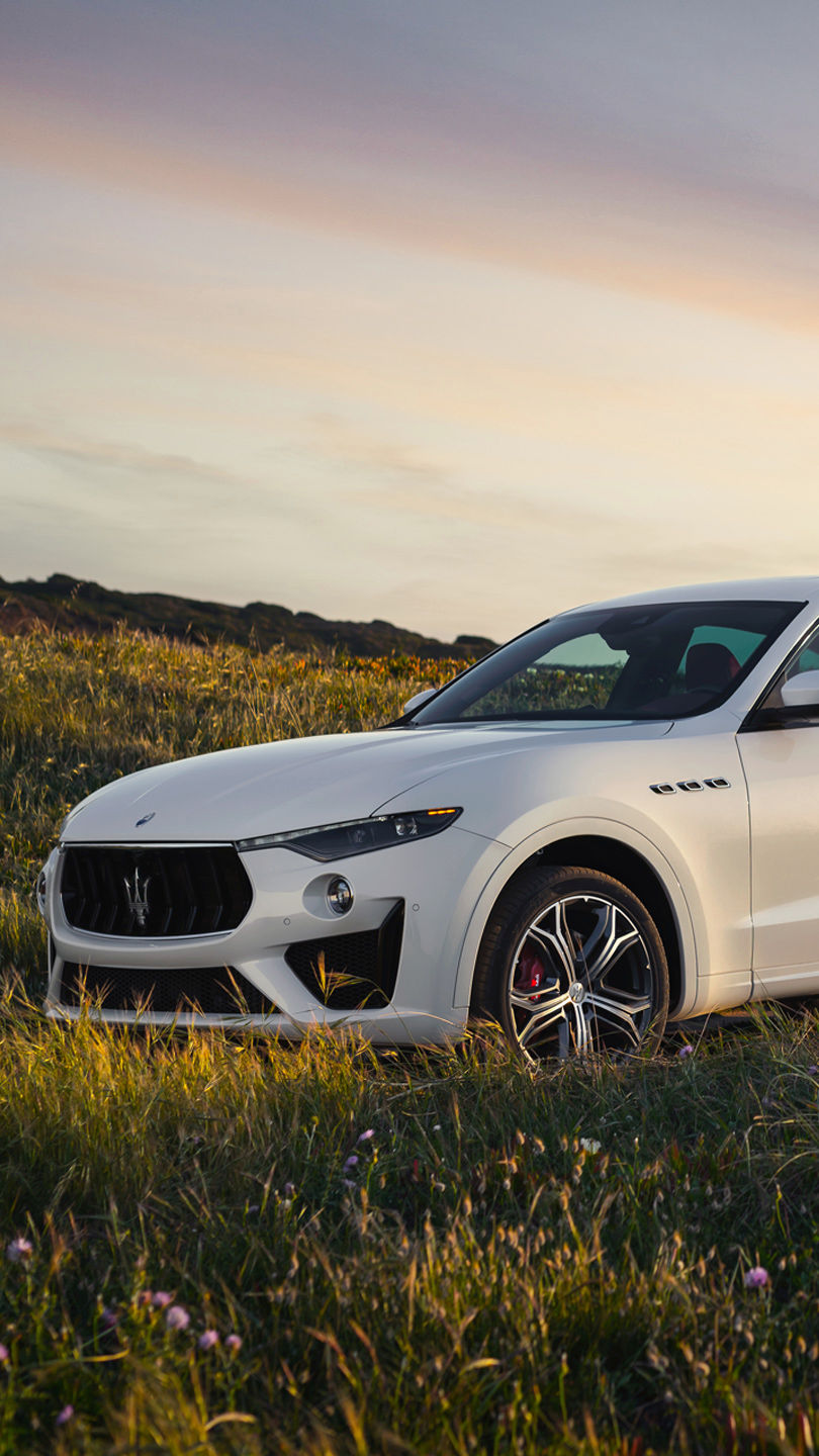 Front view of white Maserati Levante in the middle of a field