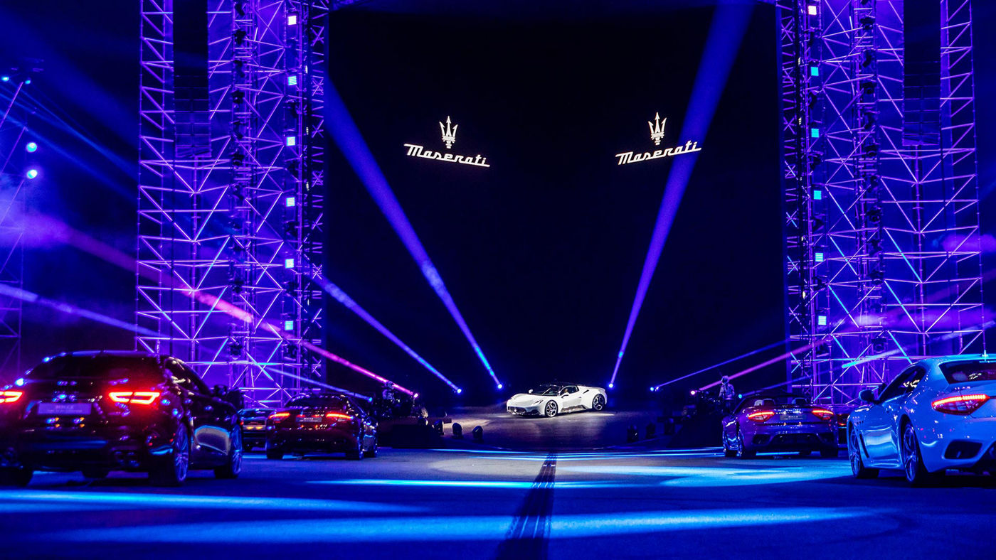 Diferentes modelos Maserati en fila que miran desde lejos el MC20
