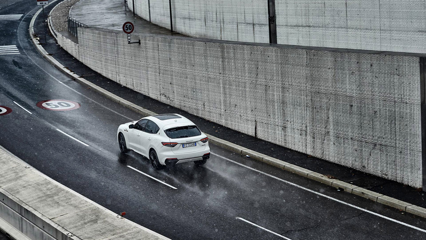 Maserati Levante Trofeo blanco por la calle con lluvia