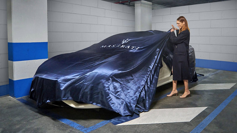 Miriam Leone deckt die Fahrzeugabdeckhaube des Maserati Ghibli Hybrid Gransport ab - Journey of Audacity 