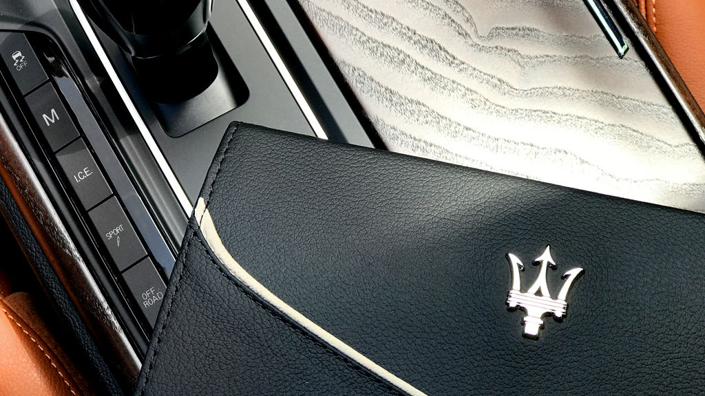 Un manuel du propriétaire placé sur la console centrale d’une Maserati Levante.