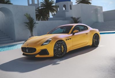 Yellow GranTurismo Trofeo sports car by pool.