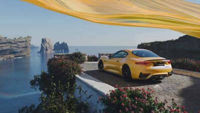 Yellow GranTurismo Trofeo sports car, rear.
